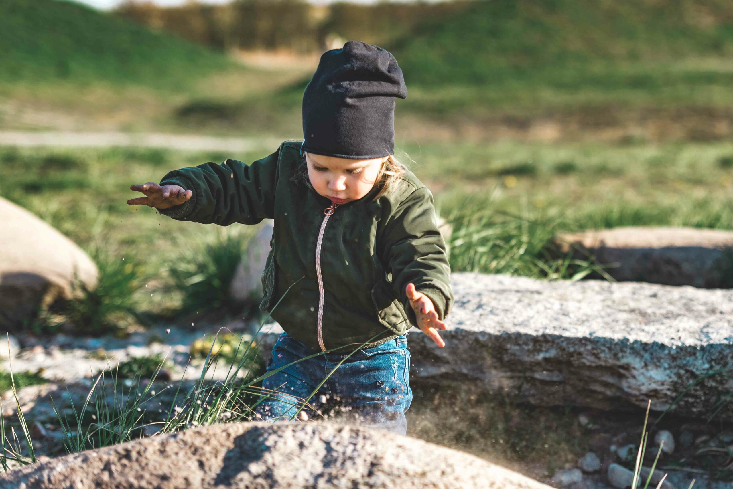 young girl playing with sand on the rock, like a magic